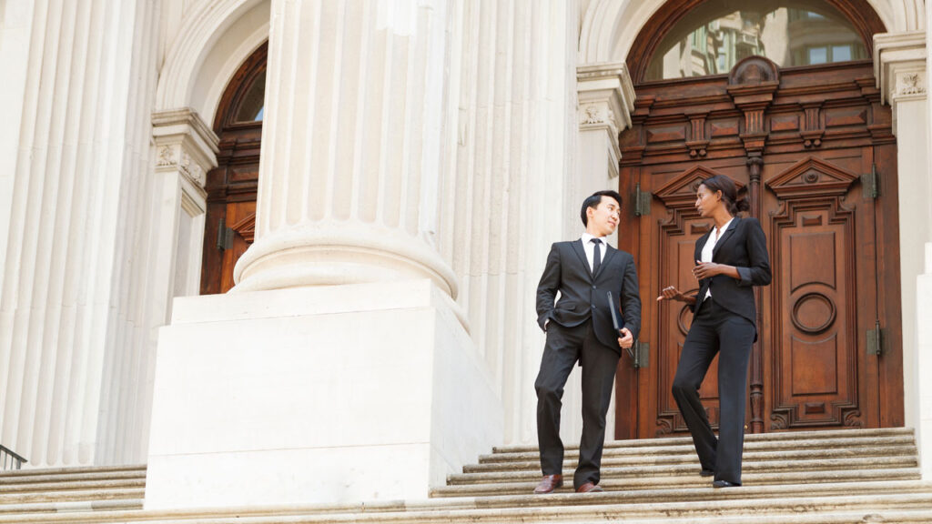 Two government workers walking on building steps discussing the BIA project