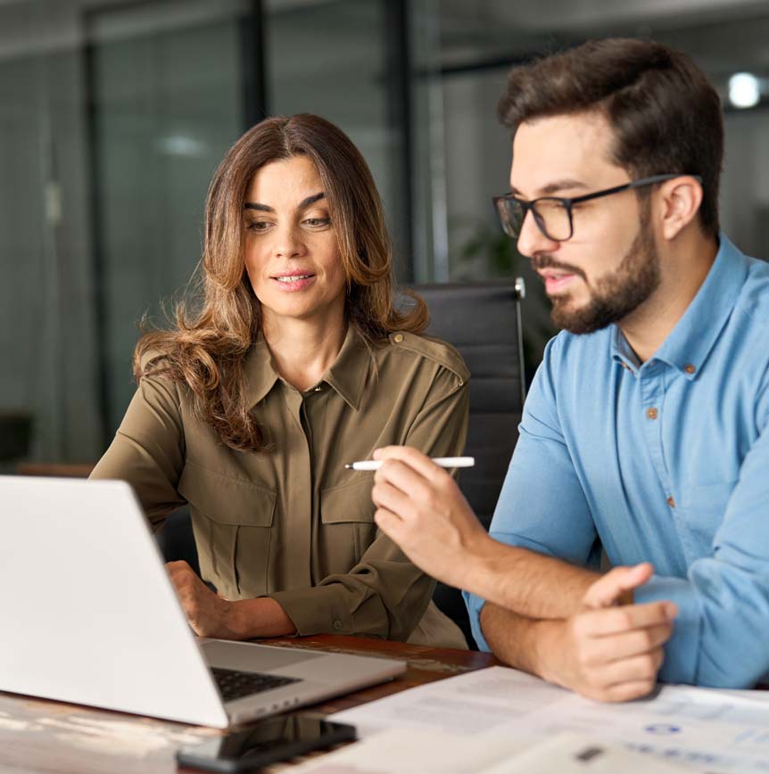 Two coworkers strategizing in front of laptop