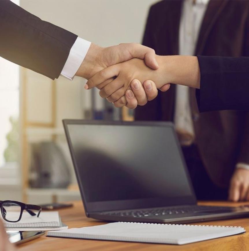 Professionals collaborating in a modern office setting, shaking hands and representing RELI Group’s government contracting solutions focused on digital transformation, program integrity, and operational efficiency.
