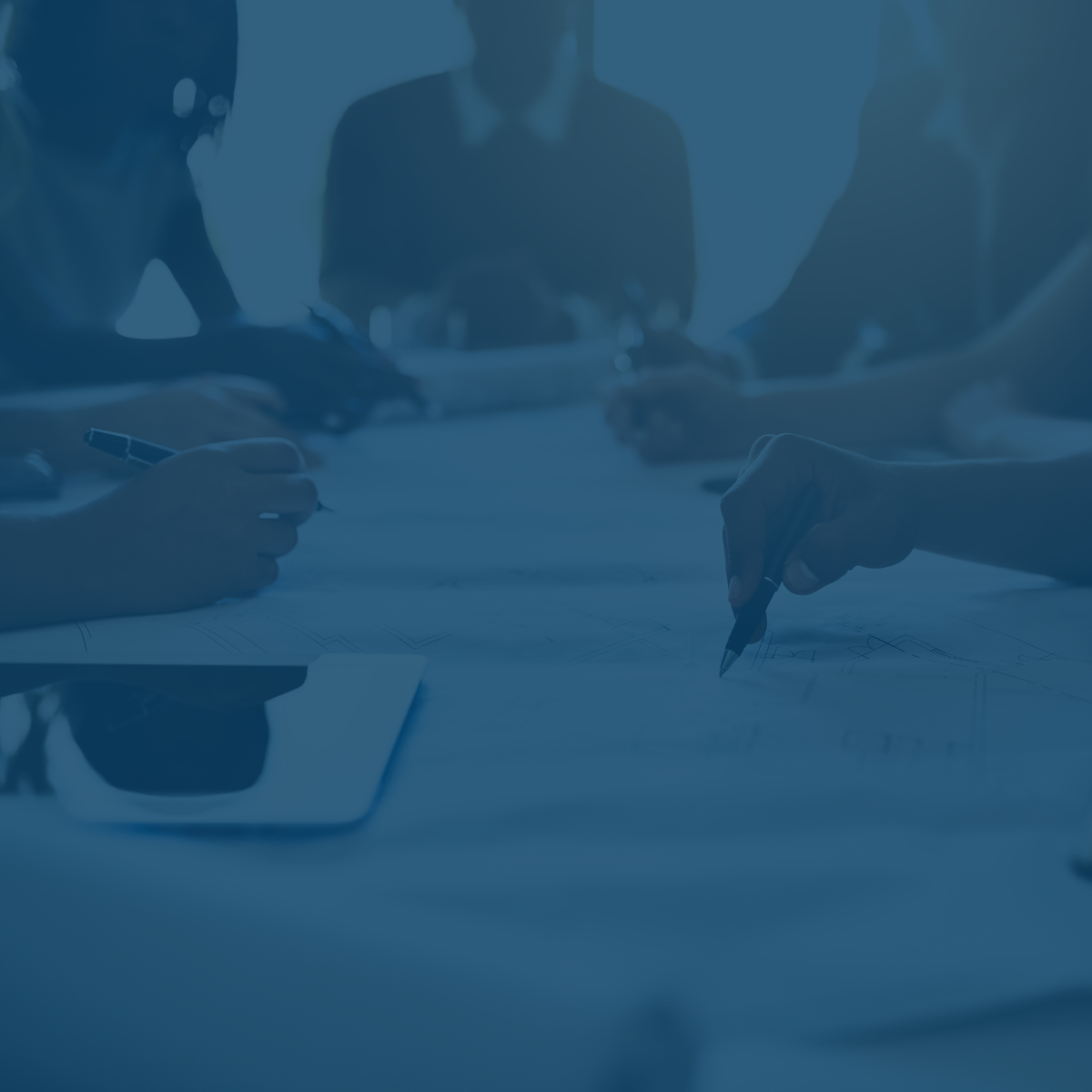 RELI Group employees at table strategizing with blue overlay.