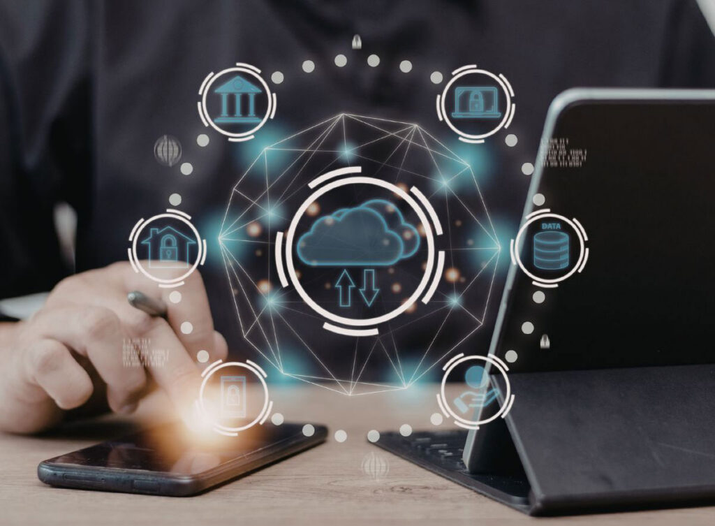 Person using a smartphone beside a laptop, with a digital overlay showing a cloud icon connected to multiple data and security symbols, representing agentic AI.