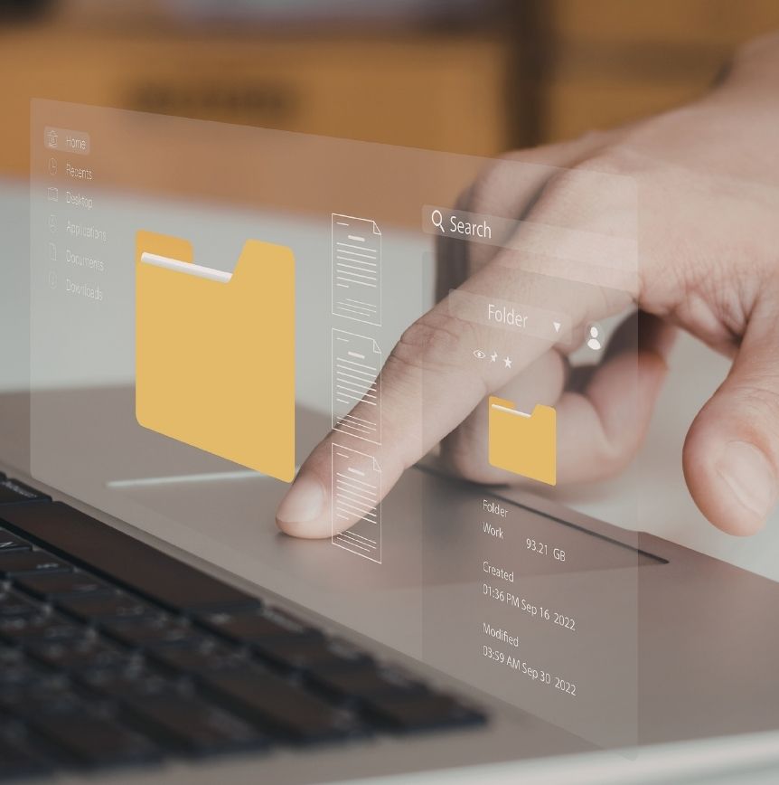 A hand interacting with a digital file folder interface projected above a laptop keyboard, managing digital clutter.