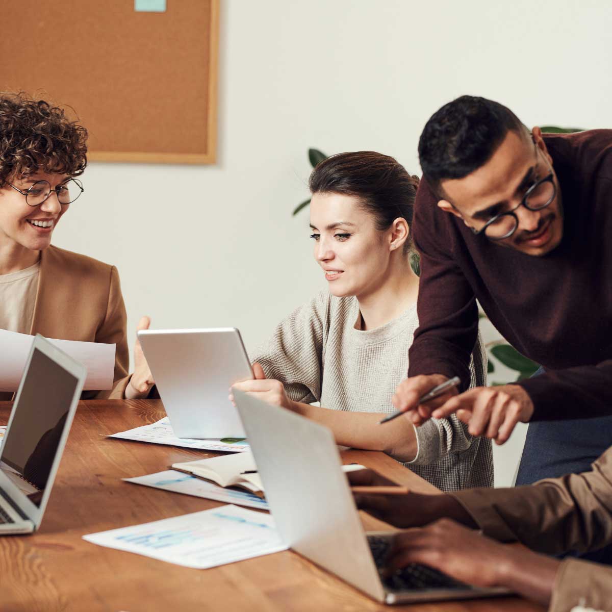 RELI Group almuni working together around a desk with laptops