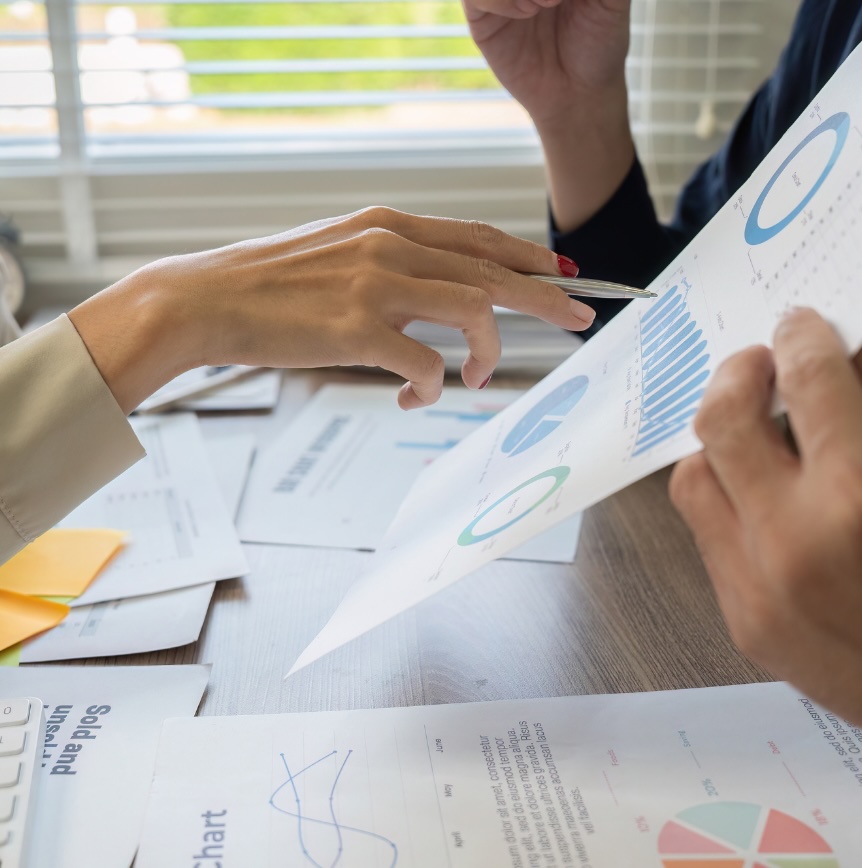 Team members review charts and reports during a discussion, illustrating how people interpret information and provide organizational context beyond documented data.