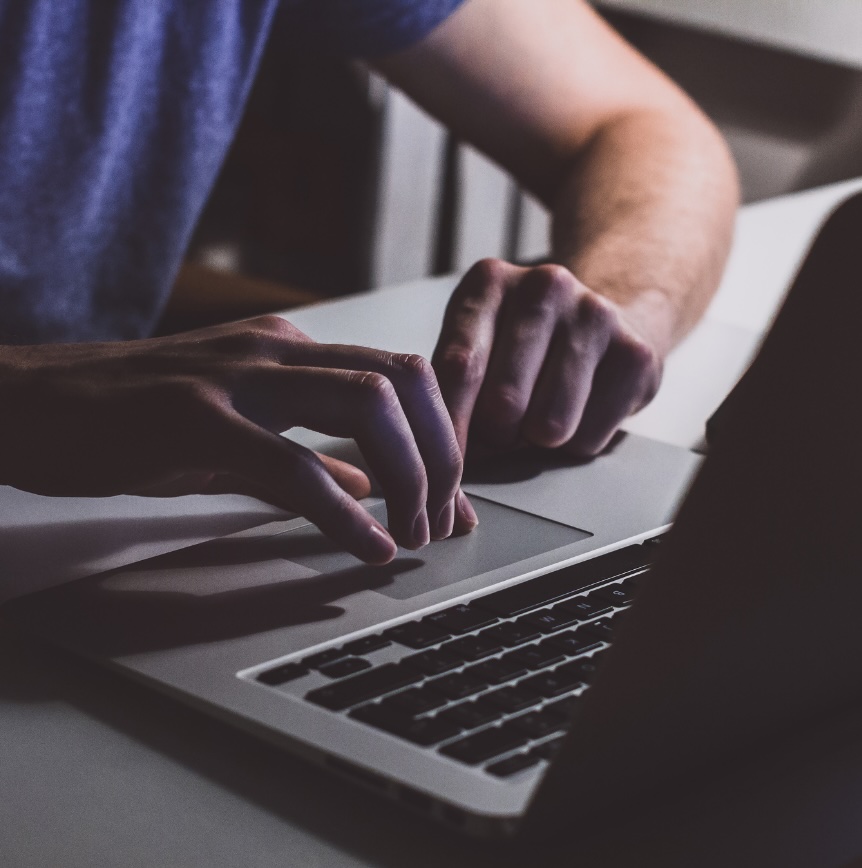 Hands using a laptop keyboard, representing everyday interactions with secure digital systems.